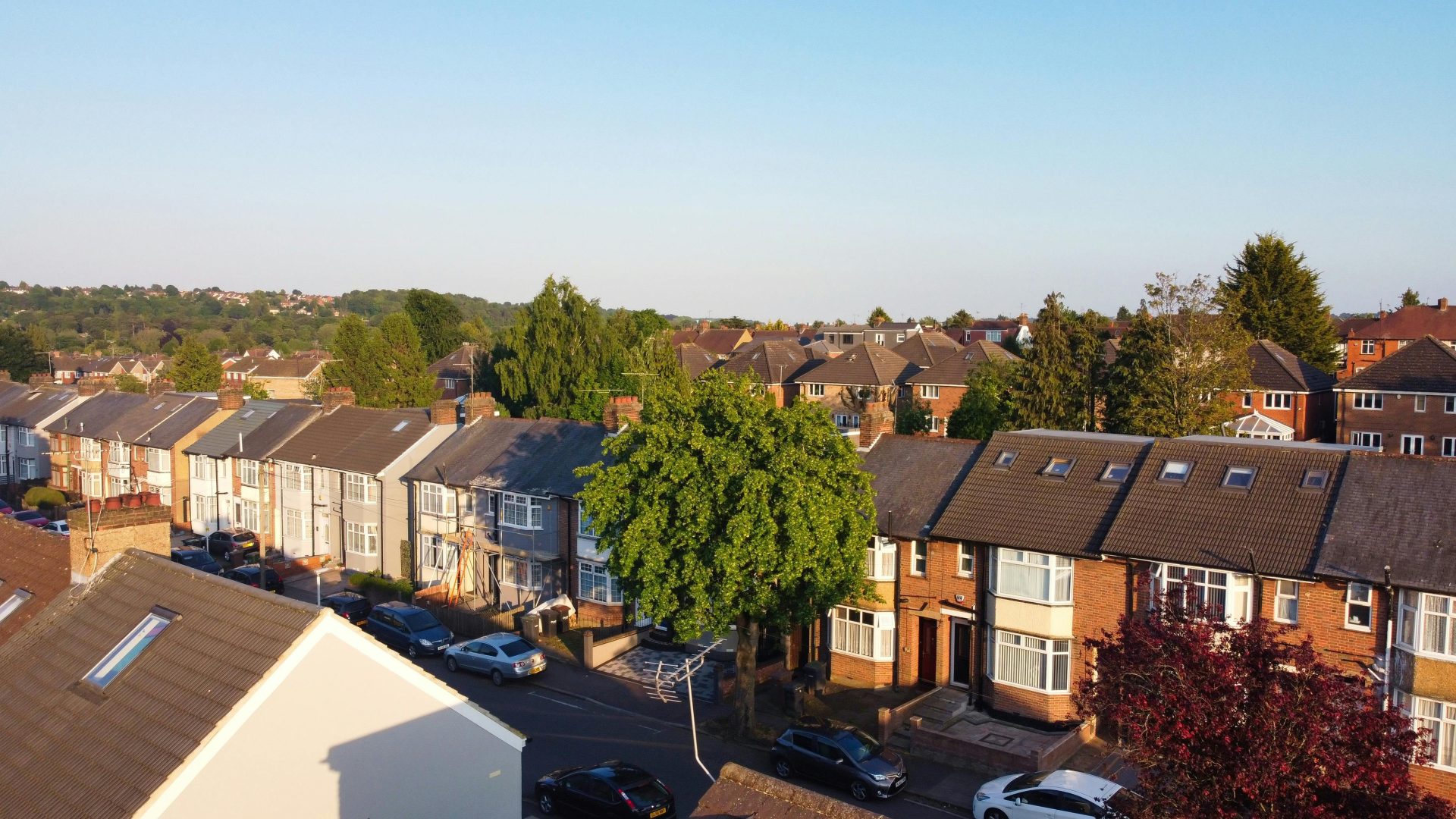 Aerial view of terraced houses and greenery in Luton, England highlights urban living.